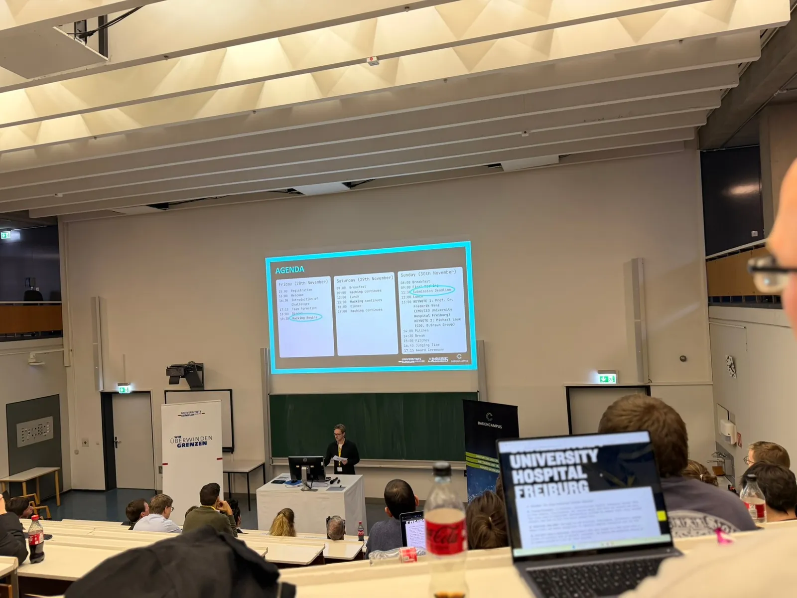 Lecture hall at the University Medical Center Freiburg with the hackathon agenda on screen