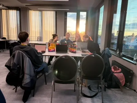 The team working on laptops at sunset