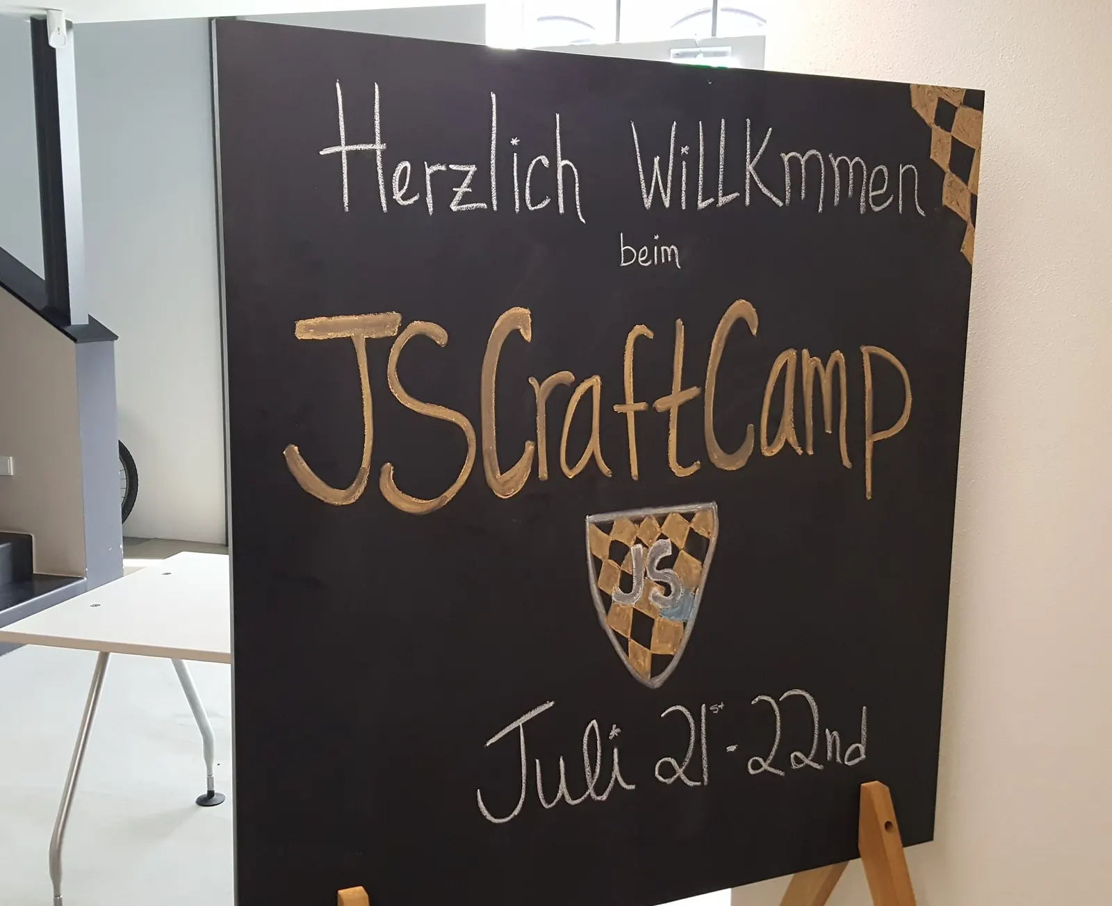 Chalkboard reading “Herzlich Willkommen beim JSCraftCamp, Juli 21.–22.”